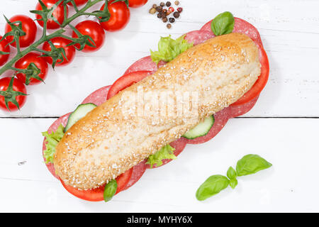 Sub tutto il sandwich di grani di grano baguette con salame di sopra sulla tavola di legno legno Foto Stock