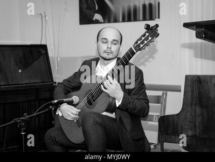 Foto in bianco e nero. Musicista con emozioni sul suo volto a suonare la chitarra. Foto Stock