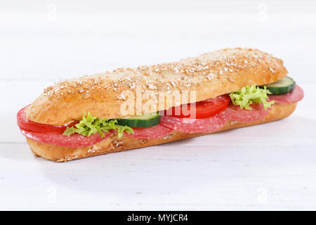 Tutto il sandwich di grani di grano baguette con salame prosciutto su tavola di legno legno Foto Stock