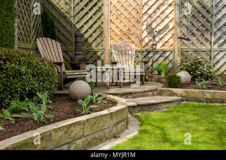 Bella e paesaggistici, giardino privato close-up con un design contemporaneo, piante di confine, posto a sedere nel patio & caratteristiche ornamentali - Yorkshire, Inghilterra, Regno Unito. Foto Stock