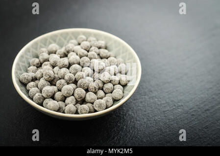 Materie Tapioca perle in piastra su nero ardesia sfondo. Per bolle di concetti di tè. Foto Stock