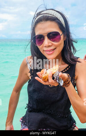 3 maggio 2018 - Arcipelago di Myeik, Myanmar. Donna Thai azienda collezione di conchiglie piuttosto dalla spiaggia Foto Stock