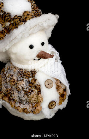 Pupazzo di neve sorridente toy vestito con sciarpa e cappuccio isolato su sfondo nero Foto Stock