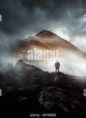 Una persona Escursionismo guarda in poi a una montagna avvolta nella nebbia e nuvole con il picco visibile. Paesaggio panoramico foto composite. Foto Stock