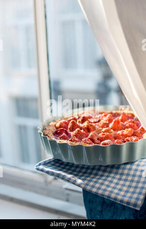 Aprire la torta con le fragole in vaso blu per la prima colazione, vicino alla finestra e la luce del giorno. In casa la cottura. Spazio libero per il testo. Spazio di copia Foto Stock