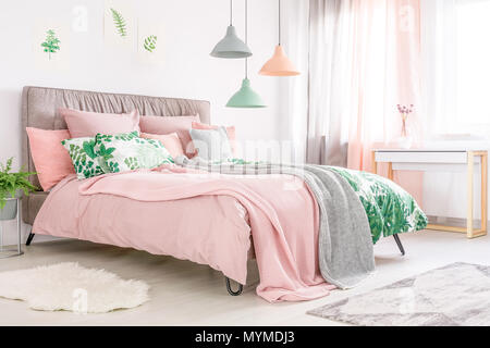 Letto king size con testata morbida e di colore rosa pastello biancheria  femminile in camera con finestra Foto stock - Alamy