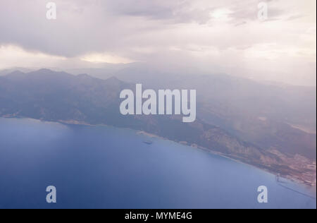 Vista aerea di una nebbiosa della costa e le gamme della montagna con la copertura nuvolosa concettuale del battenti e viaggi Foto Stock