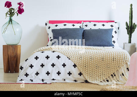 Contemporanee camere da letto eclettico con croce copripiumino e coperta di maglia Foto Stock