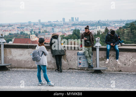 Praga, 21 Settembre 2017: i giovani sul ponte di osservazione. Ragazzi utilizzare telefoni cellulari. Una ragazza che ammira la vista della città e beve birra tipica ceca Foto Stock