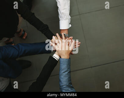 Vista superiore della gente di affari di mettere le loro mani insieme. Pila di mani. Unità e il lavoro di squadra concetto. Foto Stock