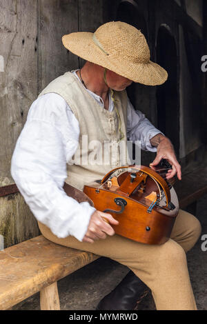 Uomo vestito in costume medievale giocando la Ghironda. Foto Stock