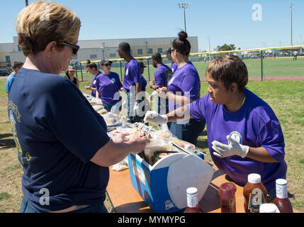 MAYPORT, Fla. (5 maggio 2017) - Ospedale Corpsman 2a classe Tomeka Raphiel-Shields, attaccato all'assalto anfibio nave USS Iwo Jima (LHD 7), serve cibo a Chief Warrant Officer 4 Toni Rand durante un comando softball torneo. I giochi sono stati mantenuti come parte di un torneo tra la nave il quadrato di poppa, Seconda Classe Petty Officer Association, Chief Petty Officer Associazione & First Class Petty Officer Associazione per costituire un cameratismo e morale tra l'equipaggio della nave. Foto Stock