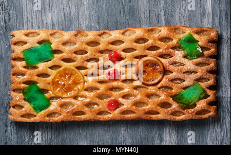 Angolo di alta vista di una coca de Sant Joan, un tipico dolce torta piatta dalla Catalogna, Spagna, mangiato su Saint Johns Eve, su un tavolo rustico Foto Stock