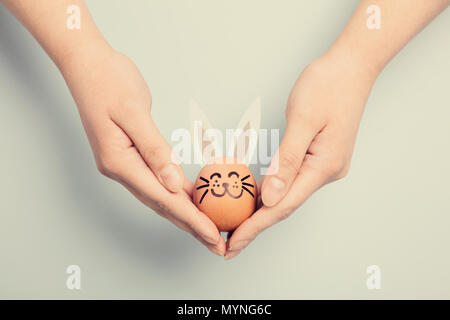 Donna di mano che tiene un coniglietto di pasqua fatta da un uovo. Vacanza tradizionale. Il cristianesimo Foto Stock