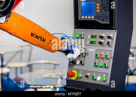 Kuka robot a braccio premendo i pulsanti sul pannello di controllo della macchina CNC Foto Stock