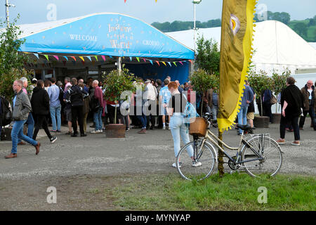 Hay Festival ingresso con bicicletta, banner e ai visitatori al di fuori, donna cercando in programma sabato sera 26 maggio 2018 Hay-on-Wye Regno Unito KATHY DEWITT Foto Stock