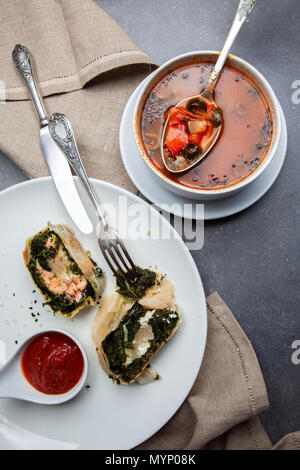 Cena con lo strudel e la Minestra sulla pietra grigia sullo sfondo Foto Stock