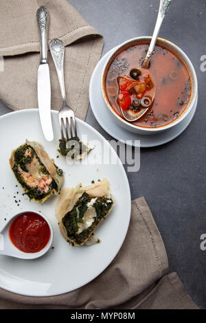 Cena con lo strudel e la Minestra sulla pietra grigia sullo sfondo Foto Stock