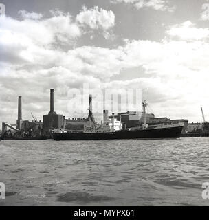 Primi anni cinquanta, vista attraverso il fiume Tamigi a sud del fiume e un lavoro di Battersea Power Station che in questo momento, aveva solo tre camini, Londra, Inghilterra, Regno Unito. Il quarto gruppo di comignoli, sud est, è stata eretta nel 1955. Foto Stock