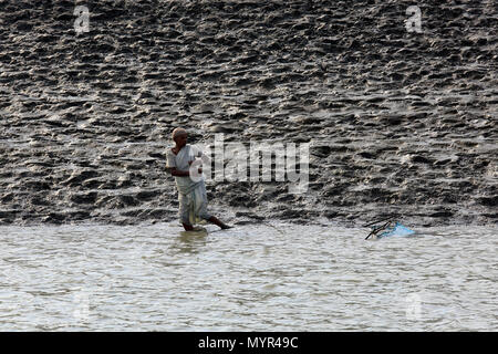 Una donna si ritiene che le catture di gamberetti giovani sul fiume Kholpetua a Gabura vicino Sundarbans. Satkhira, Bangladesh. Foto Stock