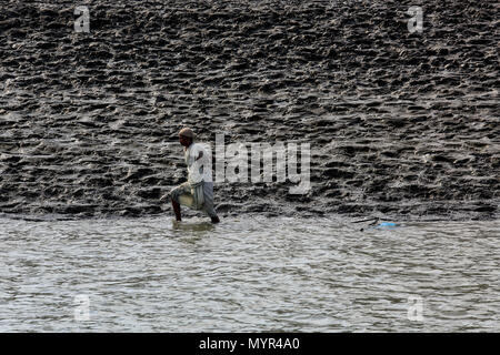 Una donna si ritiene che le catture di gamberetti giovani sul fiume Kholpetua a Gabura vicino Sundarbans. Satkhira, Bangladesh. Foto Stock