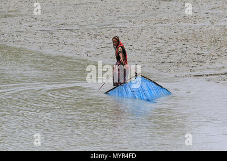 Una donna si ritiene che le catture di gamberetti giovani sul fiume Kholpetua a Gabura vicino Sundarbans. Satkhira, Bangladesh. Foto Stock