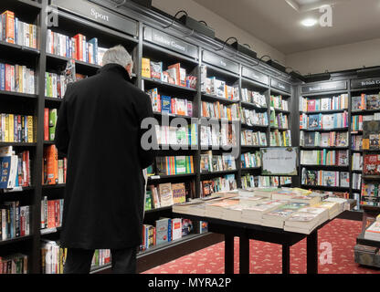 Vista posteriore di uomo maturo della lettura in Waterstones bookshop. Regno Unito Foto Stock