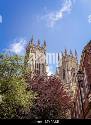 Ad ovest le torri della cattedrale di York Minster innalzarsi al di sopra delle case di una strada vicina. Foto Stock