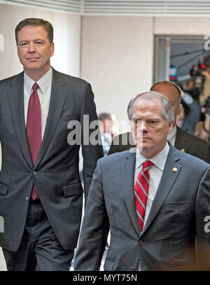 In questo file di foto da Giovedì, Giugno 8, 2017, James A. Wolfe, 58, ex direttore della sicurezza per il Senato Comitato di intelligence, destra, passeggiate con ex direttore dell'FBI James Comey, sinistra, come egli si allontana dopo testimoniare in un udienza chiusa su l'intervento russo nel 2016 elezione presidenziale prima che il senato degli Stati Uniti di Comitato di selezione sulla Intelligence al Campidoglio di Washington DC. Wolfe è stato incriminato il 7 giugno 2018 per giacente al FBI circa i ripetuti contatti con tre giornalisti e passaggio di informazioni classificate dalla Commissione a due di essi. Credito: Ron Sachs / Foto Stock