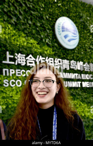 (180608) -- QINGDAO, Giugno 8, 2018 (Xinhua) -- Junusbekova Meruyert è al media center del XVIII Organizzazione per la cooperazione di Shanghai (SCO) summit a Qingdao, Cina orientale della provincia di Shandong, Giugno 8, 2018. Meruyert da Almaty, Kazakhstan aveva un sogno di studiare e vivere in Cina. Dopo aver trascorso un anno di apprendimento a cinese dello Shandong University of Technology, ella divenne uno studente di specializzazione in ingegneria del petrolio presso l Università cinese di petrolio nel 2014. Come un membro dello staff del XVIII Vertice SCO, Meruyert offre servizi per i giornalisti kazako, aiutandoli a conoscere la città e il vertice bett Foto Stock