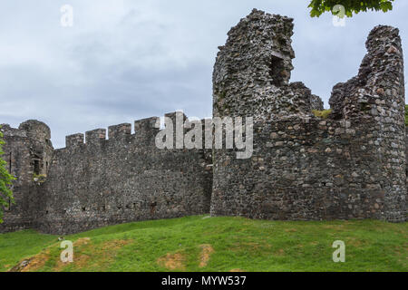 Torlundy, Scozia - Giugno 11, 2012: Comyn torre angolare in grigio-marrone pietra naturale muraglia difensiva con bastioni di Inverlochy Castle. Impostare sotto verde Foto Stock