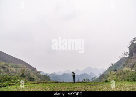 Un motociclista controllare la mappa sul suo dispositivo mentre facendo il Ha Giang Loop in Ha Giang Provincia ,Vietnam del Nord Foto Stock