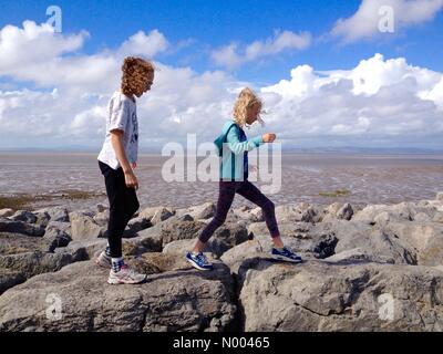 Meteo Regno Unito 29 agosto 2015. Pomeriggio di sole a Morecambe in Lancashire . Due giovani ragazze divertirsi sul lungomare a Morecambe con la baia di Morecambe situata dietro. Foto Stock