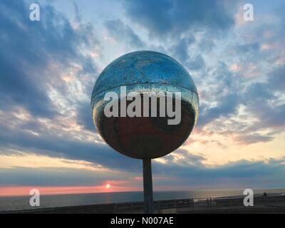 Regno Unito meteo. Tramonto a Blackpool dopo una gloriosa giornata di sole. Glitter gigante palla su South Promenade Foto Stock