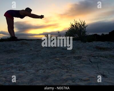 N capitale del Texas Hwy, Austin, Texas, Stati Uniti d'America. Xx Giugno, 2016. Sunrise in Austin, Texas, Stati Uniti d'America. Un escursionista si estende dopo la scalata verso la cima del ponte 360 si affacciano in Austin, prima di continuare la loro escursione. Credito: Sidney Bruere/StockimoNews/Alamy Live News Foto Stock