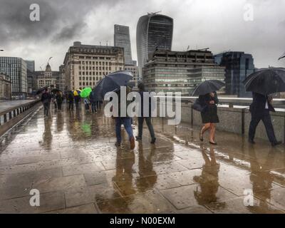 Londra, Regno Unito. 6 Giugno, 2017. Regno Unito Meteo. Pendolari cross London Bridge sotto la pioggia. Anti terrore gli ostacoli sono stati installati in quanto un attacco terroristico su London Bridge e di Borough Market Sinistra 7 morti e decine di feriti di sabato 3 giugno 2017 Credit: Louisa Cook/StockimoNews/Alamy Live News Foto Stock