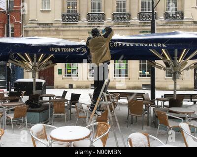 Regno Unito - meteo neve in Hereford- Domenica 18 Marzo 2018 - Personale a un open air cafe lotta per cancellare la neve nel centro della citta'. Foto Stock