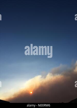 Rivington fire invia le nuvole di fumo di Adlington in Lancashire. Sole che tramonta dietro la nuvola di fumo dalla brughiera fuoco sulla Collina d'inverno. Foto Stock