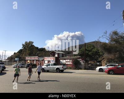 Malibu, California, USA. 9 Nov, 2018. Pedoni procedura dettagliata parcheggio con il pennacchio di fumo dal Malibu incendi in background. Credito: Todd Felderstein/StockimoNews/Alamy Live News Foto Stock