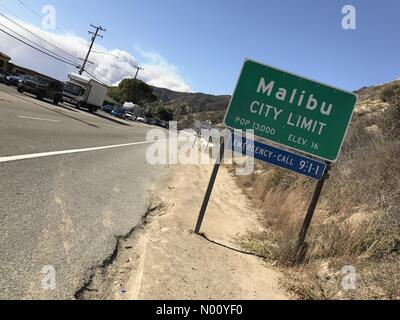 Malibu, California, USA. 9 Nov, 2018. Malibu città segno limite ai piedi della Pacific Coast highway con un pennacchio di fumo derivante dalla combustione di incendi in background Credito: Todd Felderstein/StockimoNews/Alamy Live News Foto Stock