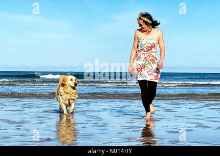 Cornovaglia, Regno Unito. Aprile 13 2021: Regno Unito Meteo: Cielo blu e sole per Raich Keene e Raffaello il Retriever sulla spiaggia di Perranporth, Cornovaglia Credit: Nidpor/StockimoNews/Alamy Live News Foto Stock