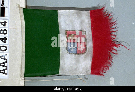 . Inglese: mercante italiano ensign (dopo 1946) Italiano merchant ensign, dopo 1946 pattern, dal Tamigi aliscafo "Freccia del Vesuvio'. La bandiera è in cotone bunting, macchina cuciti con un filo collegato per il sollevamento. Il fly bordo è molto logora. Tre strisce verticali in verde, bianco e rosso sono stampati sulla bandiera. Sulla striscia centrale di uno scudo, confina con corda in oro, con la quarterings: 1) rosso con il leone di San Marco in oro (Venezia). 2) Bianco con la croce rossa di St George (Genova). 3) blu con una Croce Maltese bianca (Amalfi). 4) rosso con croce di Pisa in bianco (Pisa). La ens Foto Stock