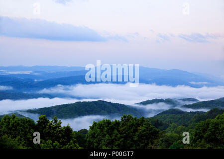 Alba dalla cima che si affaccia su bassa velatura nelle valli sottostanti Foto Stock