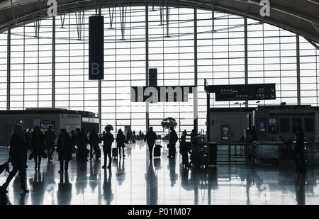 Shanghai, Cina - 6 Dicembre 2014: i passeggeri a piedi nella sala di attesa dell'Aeroporto Internazionale di Shanghai Pudong. Back lit foto con sagome scure Foto Stock