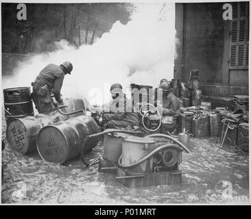 I soldati del 161fumo chimica società di generazione, U.S. Terza Armata, spostare un barile di petrolio in preparazione per riempire - Foto Stock