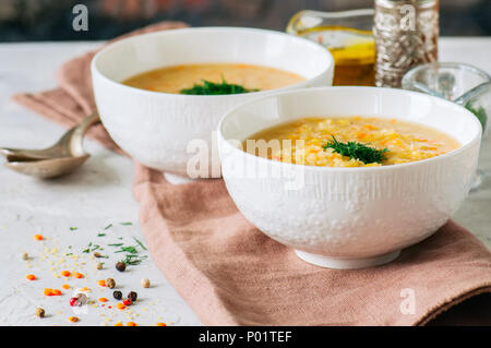 Lenticchia e zuppa di bulgur purea in una ciotola bianco su una pietra bianca dello sfondo. Foto Stock