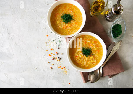 Lenticchia e zuppa di bulgur purea in una ciotola bianco su una pietra bianca dello sfondo. Foto Stock