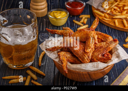 Ali di bufalo con patatine fritte e birra, il fuoco selettivo. Foto Stock