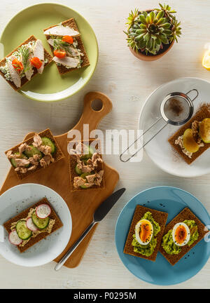 Panini sani con vari ripieni su croccante pane di segale, vista dall'alto. Foto Stock