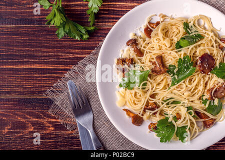 Pasta Spaghetti con funghi finferli su sfondo di legno, vista dall'alto. Foto Stock